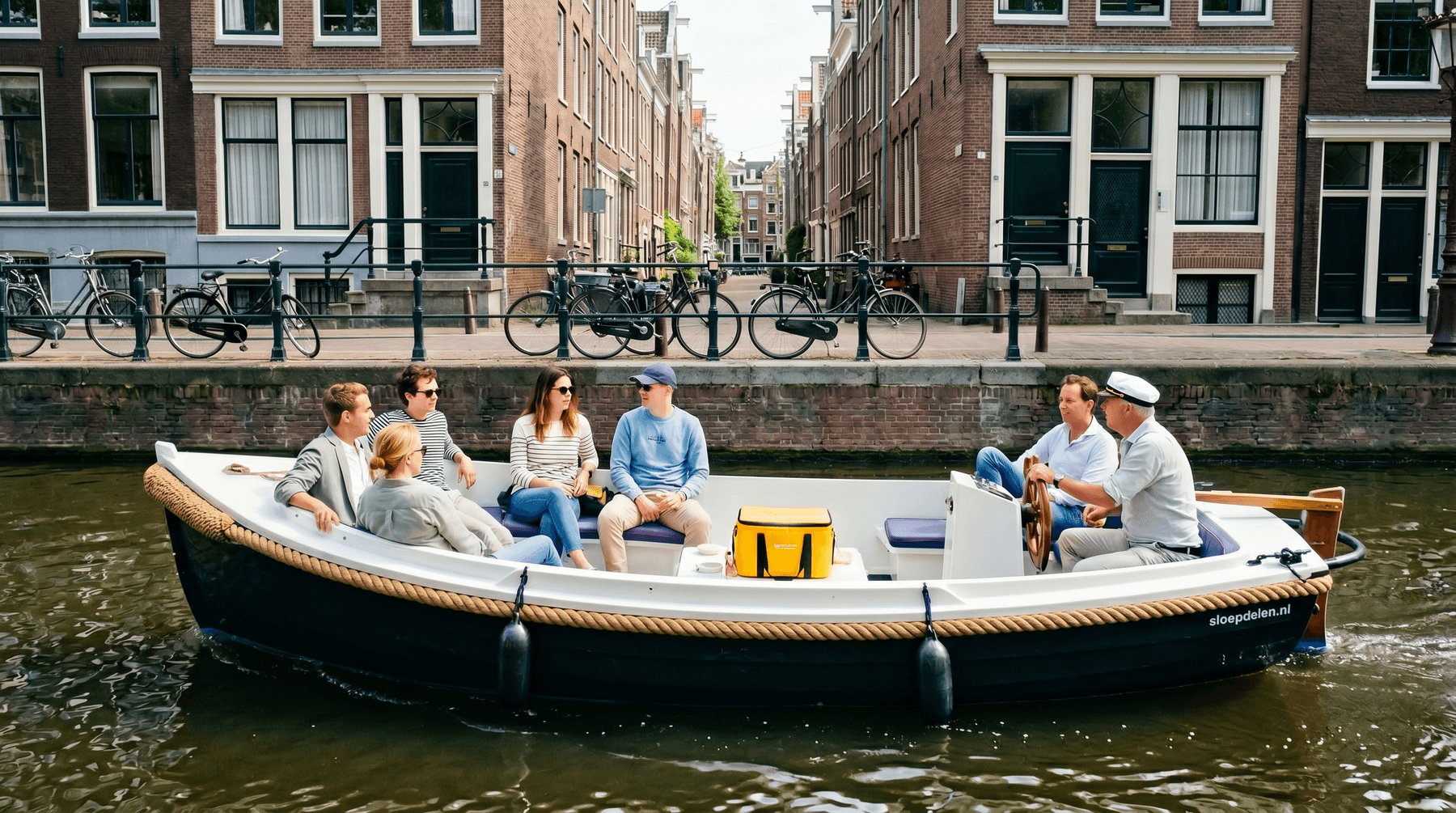 Bedrijfsuitje varen Amsterdam, sloep op een zonnige Amsterdamse gracht